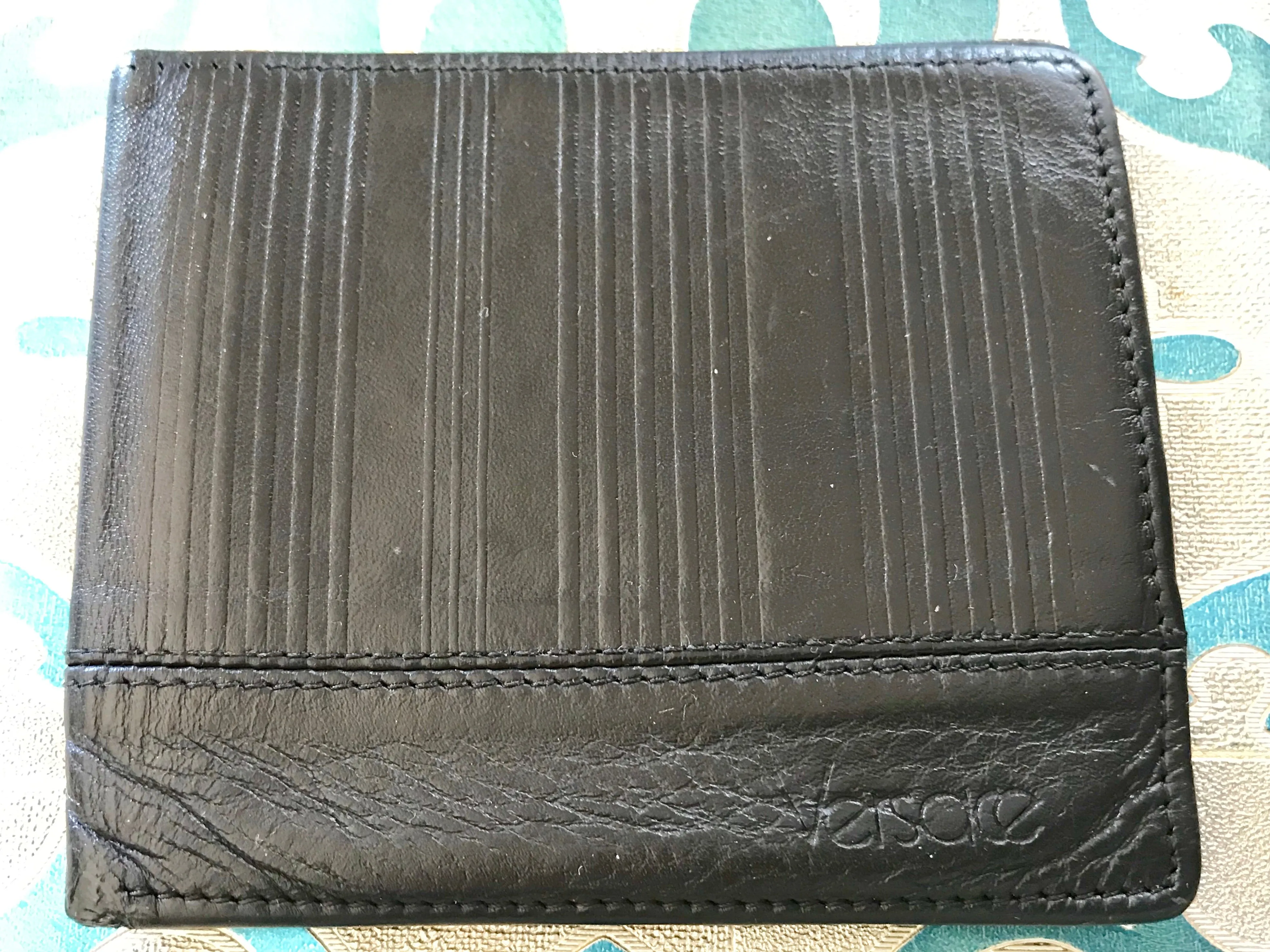 Vintage Gianni Versace black leather wallet with engraved vertical stripe. Unisex use.