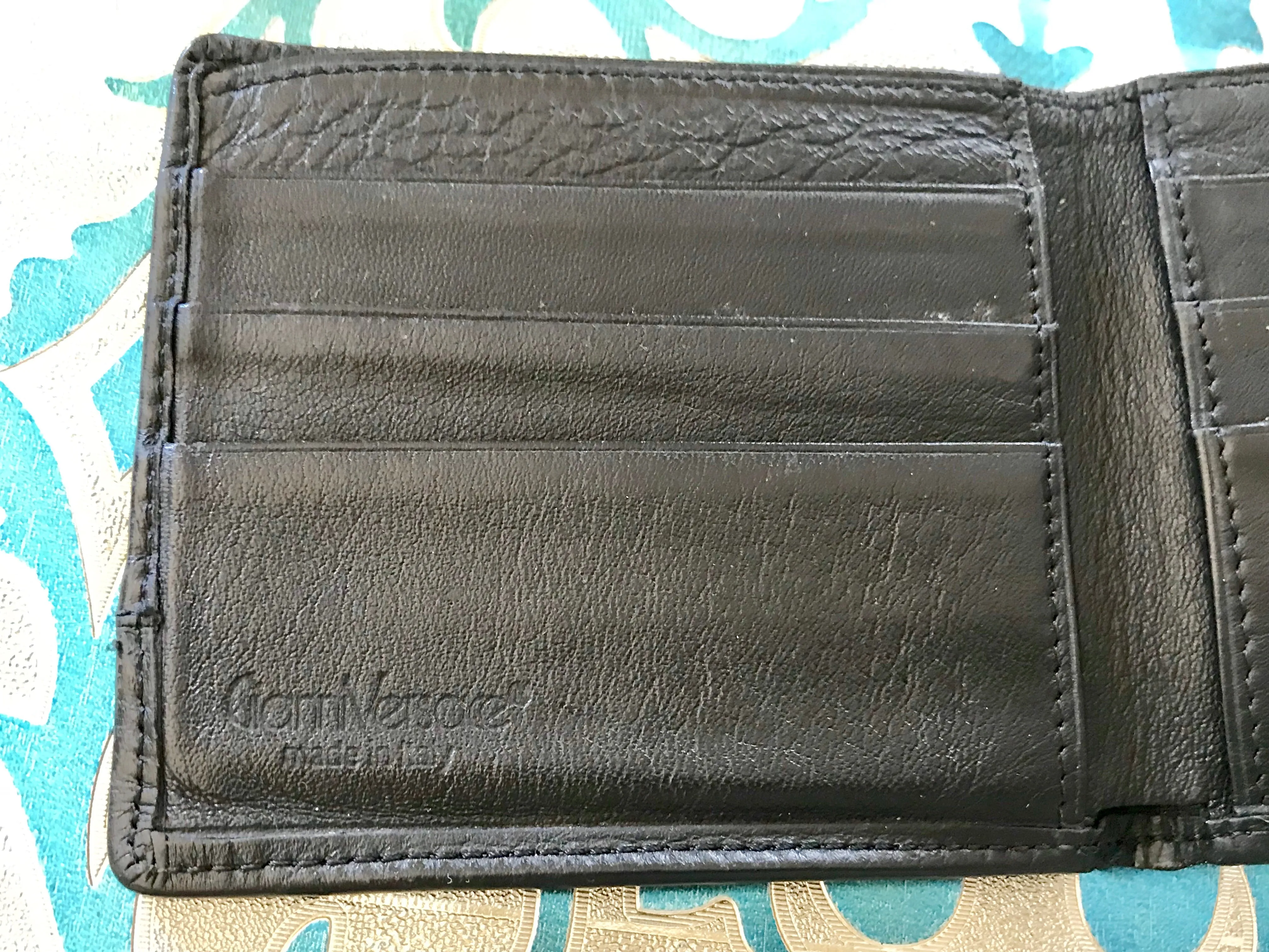 Vintage Gianni Versace black leather wallet with engraved vertical stripe. Unisex use.